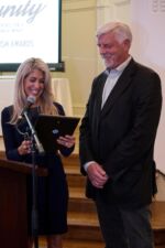 Doug Swift accepts an award on behalf of Mark Goldman, presented by Aliesa Adelman. Doug Swift accepts an award on behalf of Mark Goldman, presented by Aliesa Adelman.